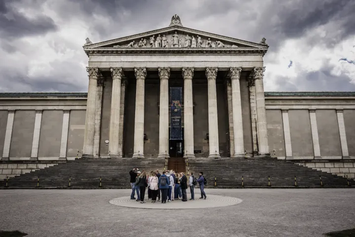 a group of people sitting on a bench in front of a building