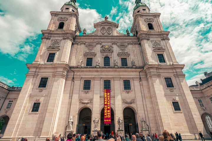 a group of people standing in front of a large building with Speyer Cathedral in the background