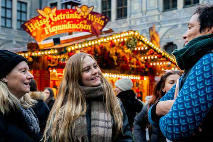 a group of people walking down the street talking on a cell phone