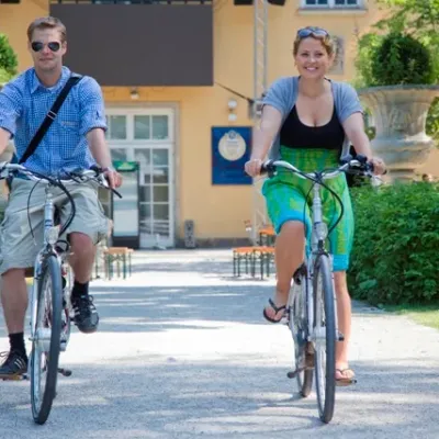 a little girl riding on the back of a bicycle
